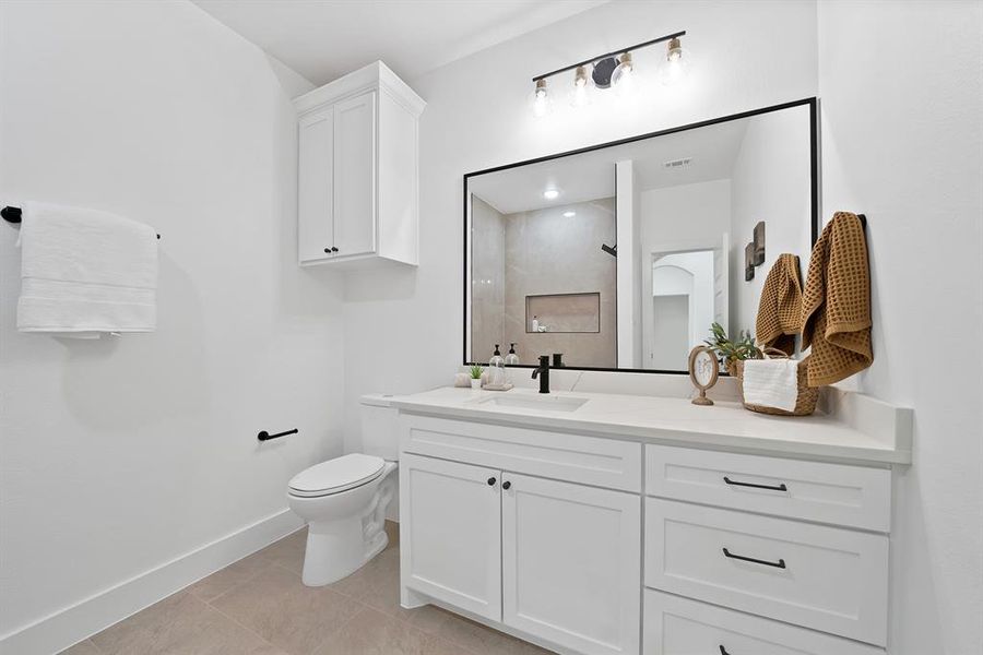 Vanity featuring a white countertop, undermount sink, and matte black faucet Vanity featuring a white countertop, undermount sink, and matte black faucet