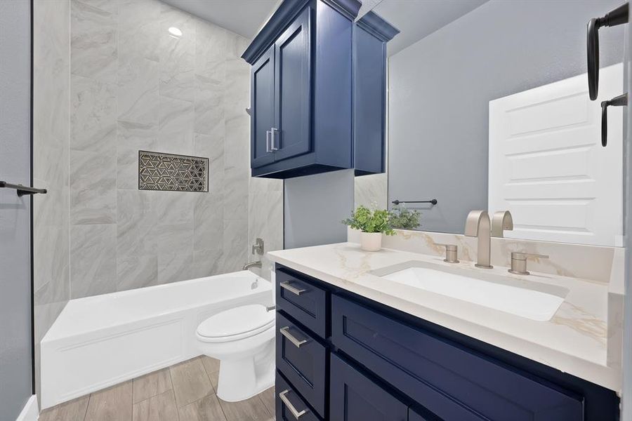 Bathroom featuring a large vanity with deep blue cabinetry, a white countertop, and a rectangular undermount sink