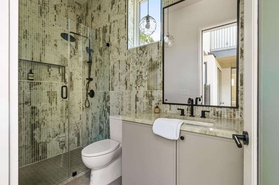 Striking textured wall tiles frame the walk-in shower and vanity in this contemporary bathroom. Striking textured wall tiles frame the walk-in shower and vanity in this contemporary bathroom.