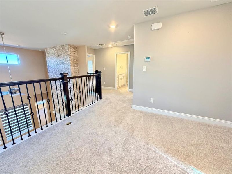 Hall featuring healthy amount of natural light, carpet, and attic access Hall featuring healthy amount of natural light, carpet, and attic access