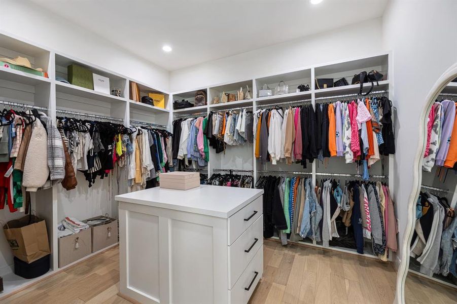 One of two walk-in closets in the primary suite. Complete with an island for added storage and elegant built-ins, ensuring that everything you need is neatly arranged and easily accessible.