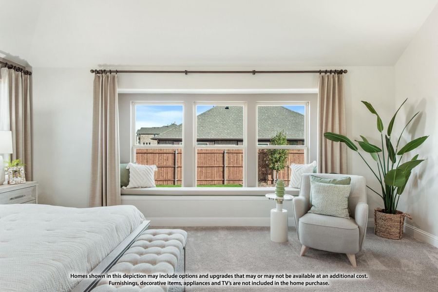 Bedroom with built-in window seat, triple windows, neutral carpet, and sitting area with accent chair Bedroom with built-in window seat, triple windows, neutral carpet, and sitting area with accent chair
