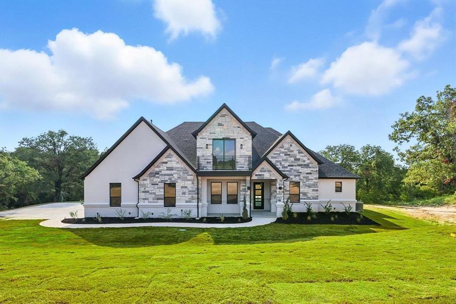 View of front of house featuring stone siding and a front lawn View of front of house featuring stone siding and a front lawn