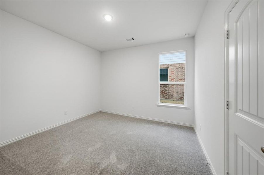 Spare room with light colored carpet and baseboards