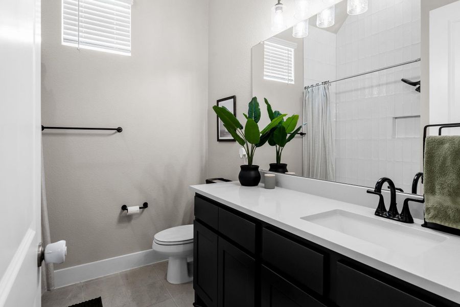 Bathroom featuring a white rectangular undermount sink, a white countertop, and a dark wood-finish vanity with matte black hardware