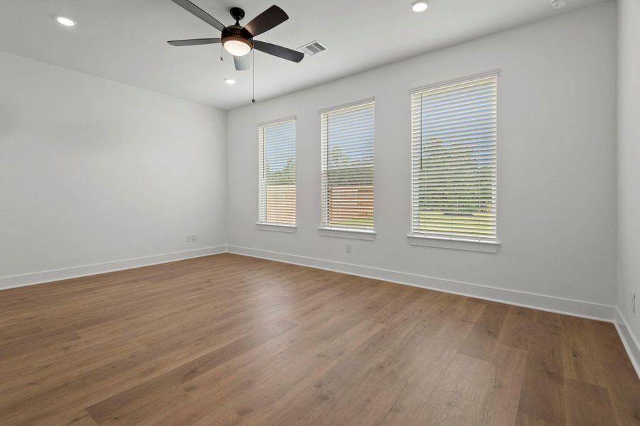 The spacious master bedroom with luxury flooring, located downstiars.
