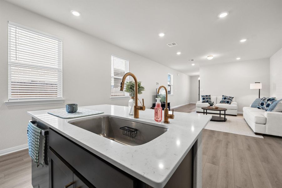 Kitchen with light wood-type flooring, open floor plan, a kitchen island with sink, light stone counters, and recessed lighting Kitchen with light wood-type flooring, open floor plan, a kitchen island with sink, light stone counters, and recessed lighting