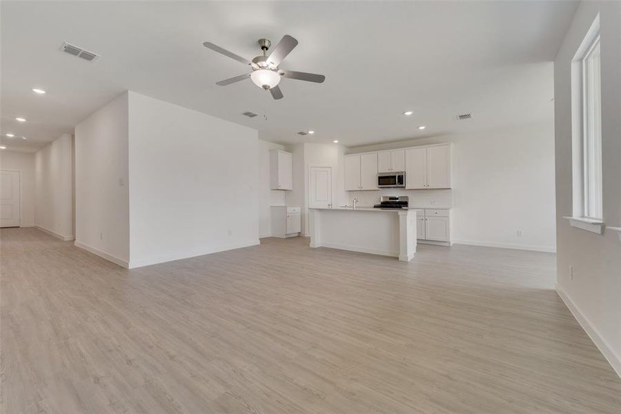 Unfurnished living room with light hardwood / wood-style floors and ceiling fan