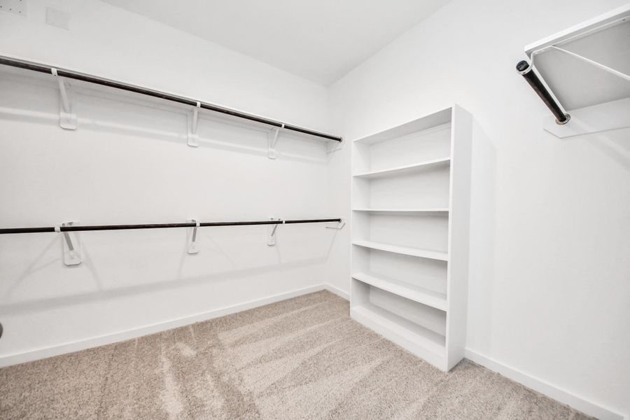 Walk-in closet that epitomizes luxury and practicality. This generously sized space features built-in shelving, offering abundant room for impeccable organization. High ceilings and recessed lighting create a bright and welcoming ambiance. Sample photo of completed home with similar floor plan. Actual colors and selections may vary. Walk-in closet that epitomizes luxury and practicality. This generously sized space features built-in shelving, offering abundant room for impeccable organization. High ceilings and recessed lighting create a bright and welcoming ambiance. Sample photo of completed home with similar floor plan. Actual colors and selections may vary.