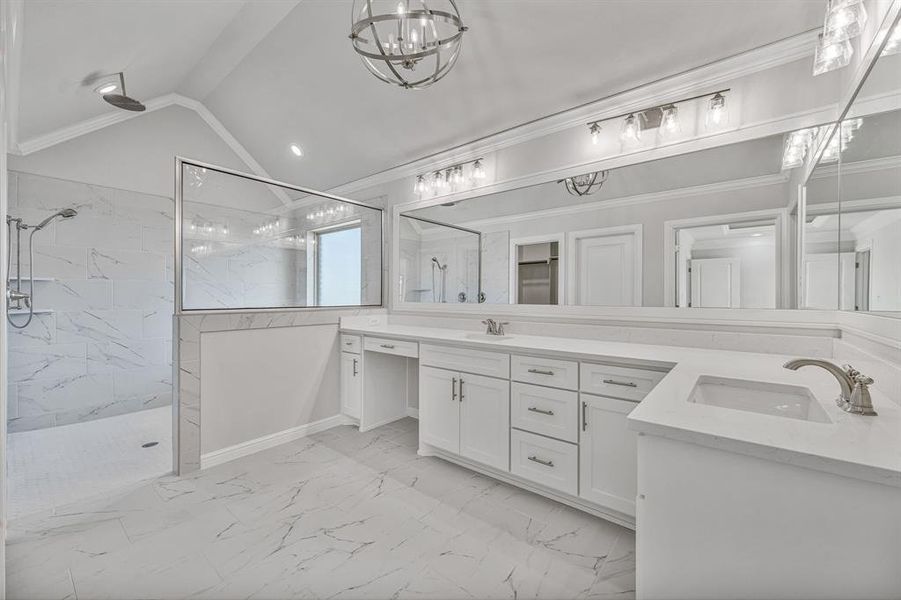 Bathroom featuring double vanity, a marble finish shower, lofted ceiling, light marble finish floors, and ornamental molding