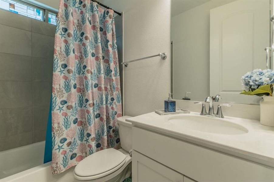 Bathroom featuring a vanity with an integrated sink, polished chrome faucet, and a large wall-mounted mirror