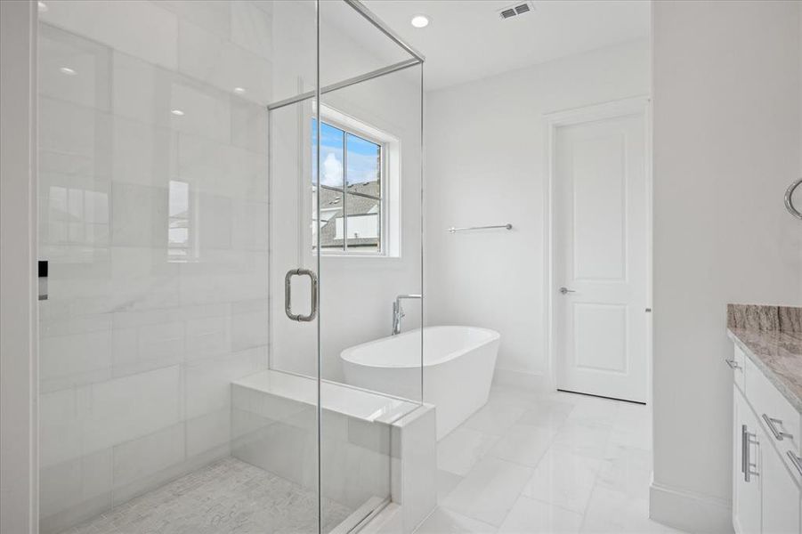 Glass-enclosed shower with white tiled walls and built-in bench