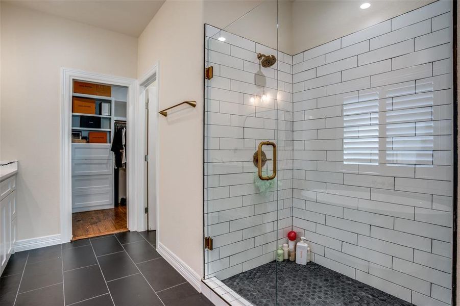 Bathroom featuring tile patterned flooring, vanity, and a shower with shower door