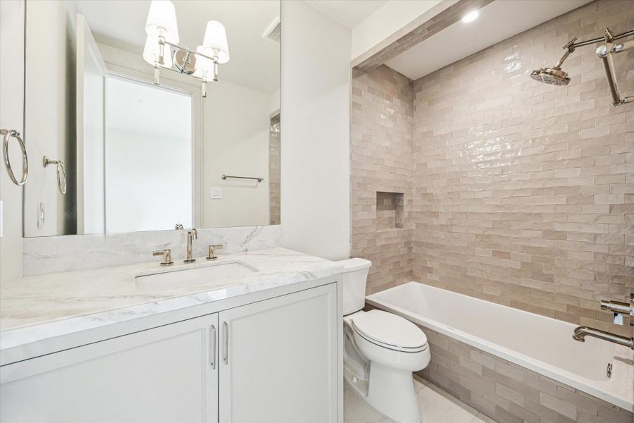 This secondary bathroom features Ecosystems Fog porcelain tile floors and Fez Warm Glass tile accent.