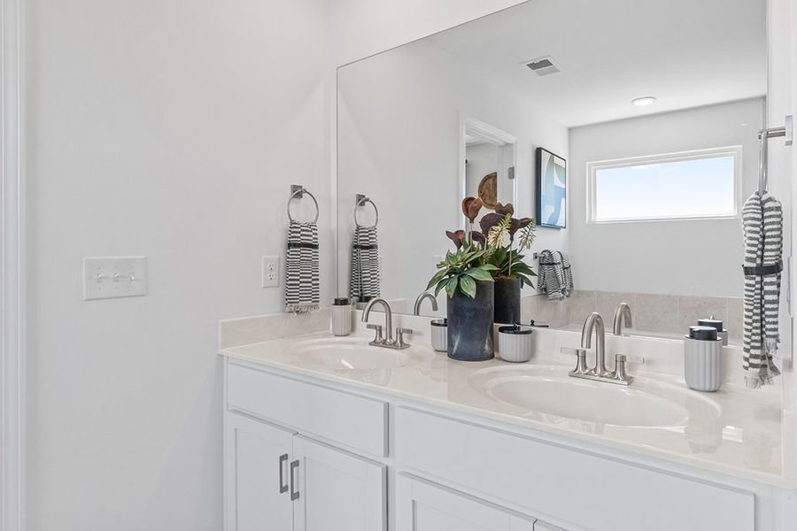 A person taking a selfie in the bathroom mirror.