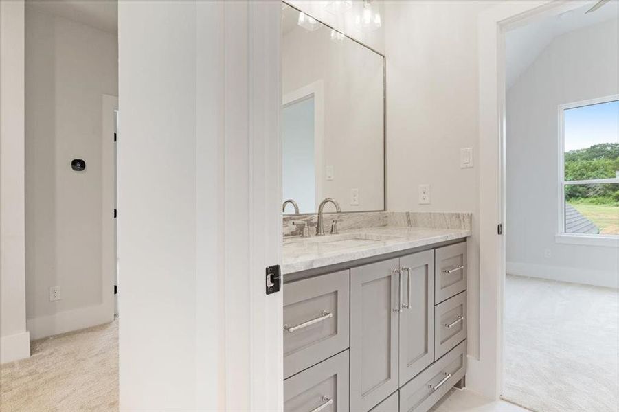 Bathroom featuring vanity and lofted ceiling