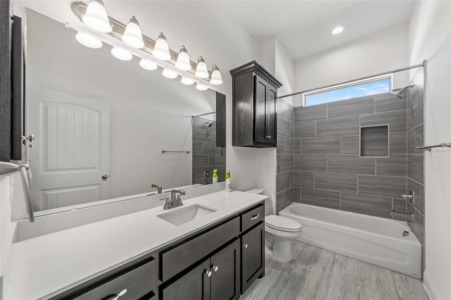 Full bath with toilet, shower / tub combination, vanity, wood finished floors, and recessed lighting