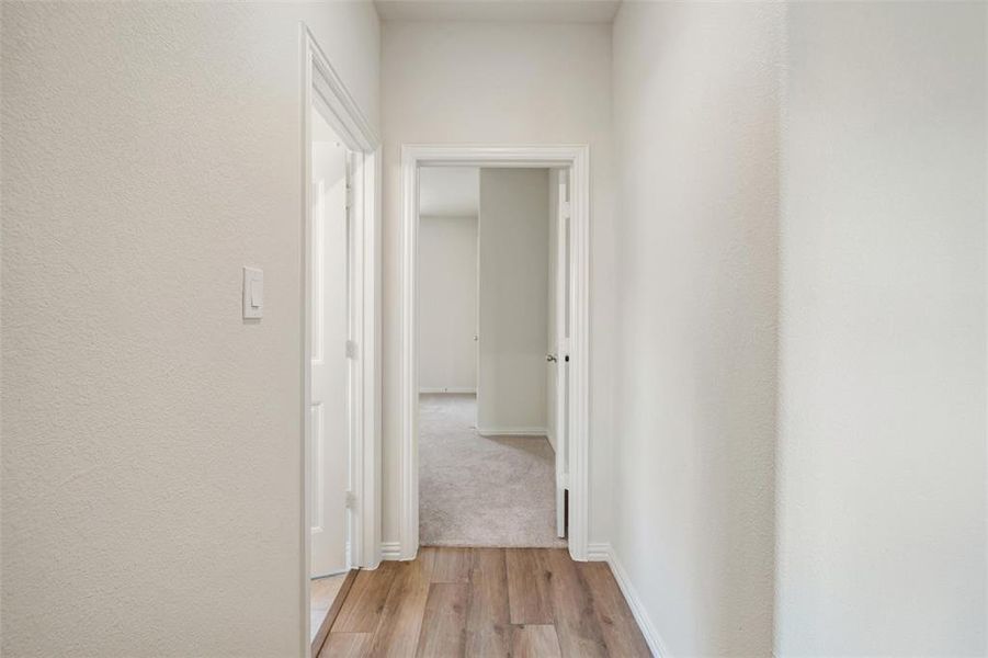 Hall with light wood-style flooring and baseboards