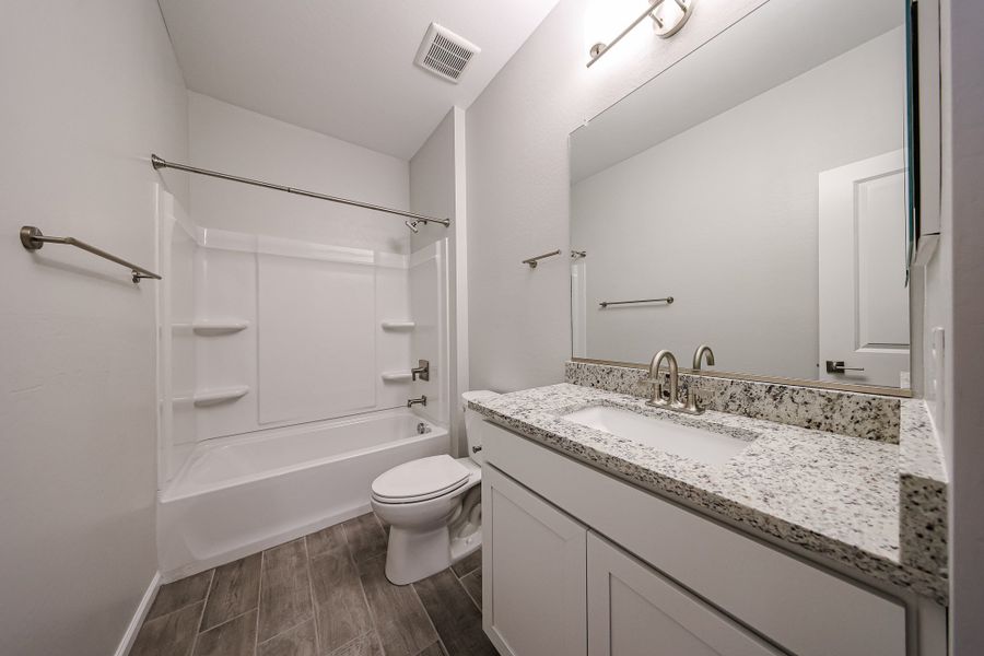 A bathroom with a tub sink and toilet.