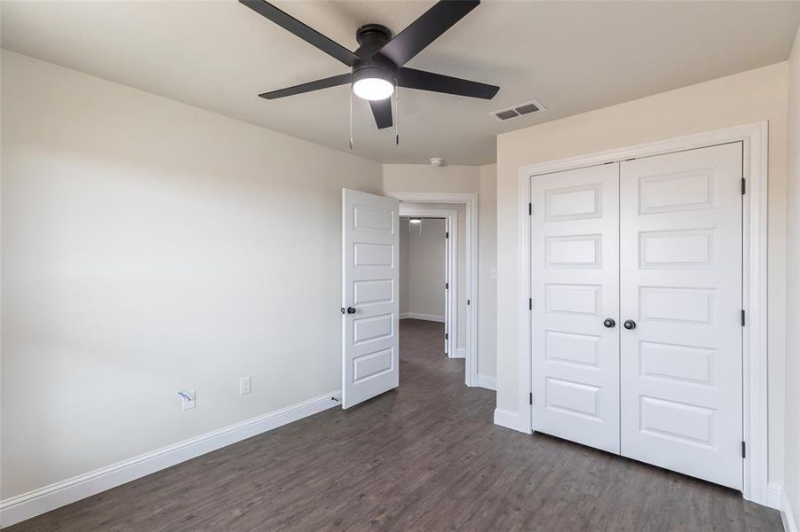 Room with wood-finish flooring, white walls, and a modern ceiling fan with integrated lighting