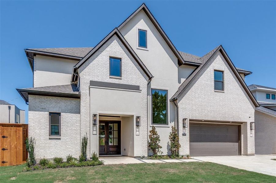 View of front facade with brick siding, stucco siding, an attached garage, concrete driveway, and a front yard View of front facade with brick siding, stucco siding, an attached garage, concrete driveway, and a front yard