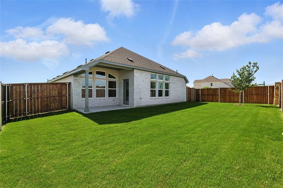 Rear view of house with brick siding, a fenced backyard, a patio, and a shingled roof Rear view of house with brick siding, a fenced backyard, a patio, and a shingled roof