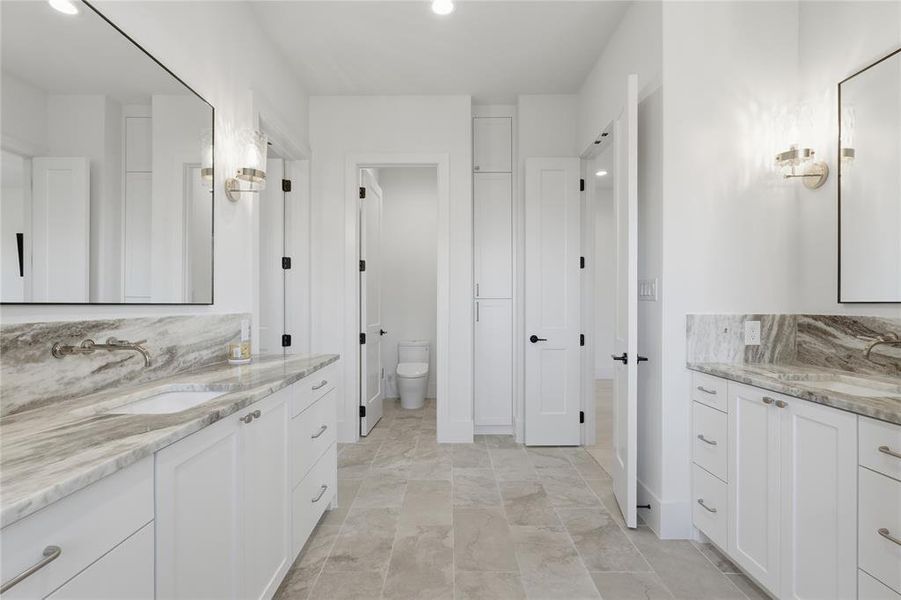 Dual vanity with undermount sinks, stone countertops, and wall-mounted faucets