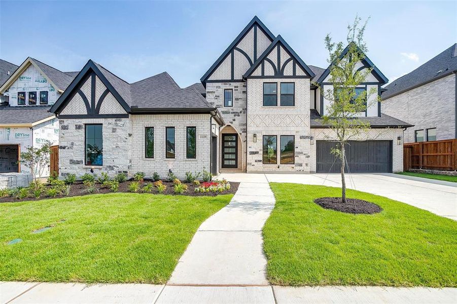 Tudor-style house with a front lawn and a garage