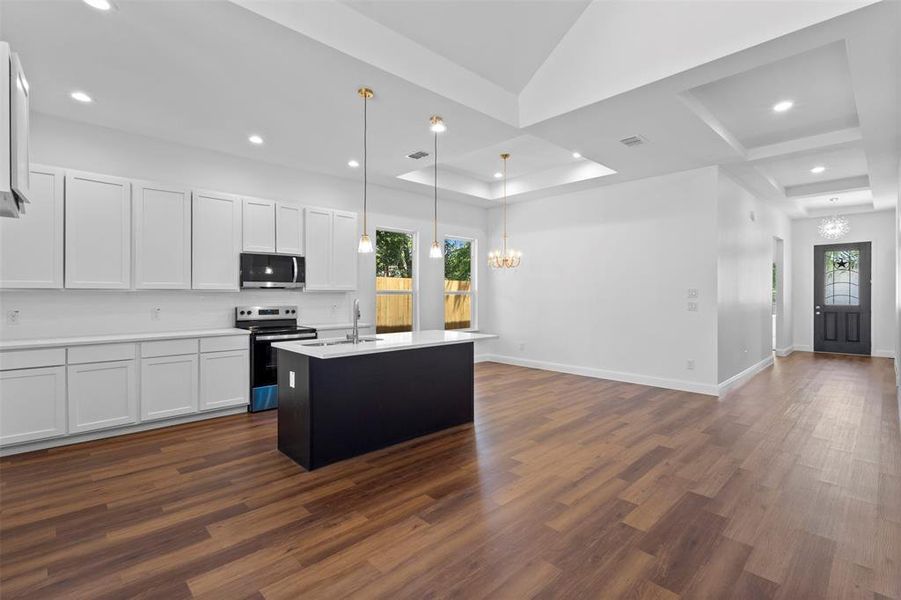 Kitchen featuring a chandelier, range with electric cooktop, dark wood-style flooring, light countertops, and recessed lighting Kitchen featuring a chandelier, range with electric cooktop, dark wood-style flooring, light countertops, and recessed lighting