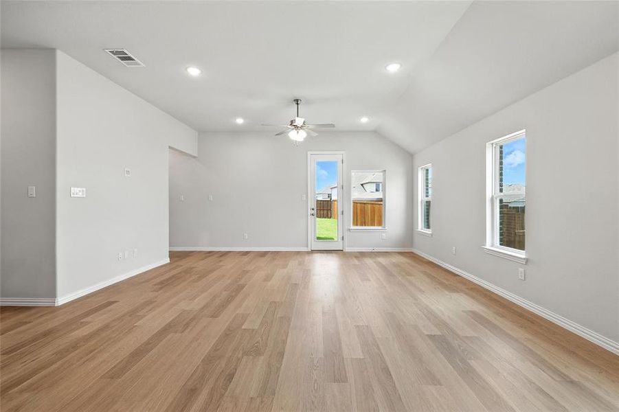 Unfurnished living room with a ceiling fan, vaulted ceiling, light wood-style floors, and recessed lighting Unfurnished living room with a ceiling fan, vaulted ceiling, light wood-style floors, and recessed lighting
