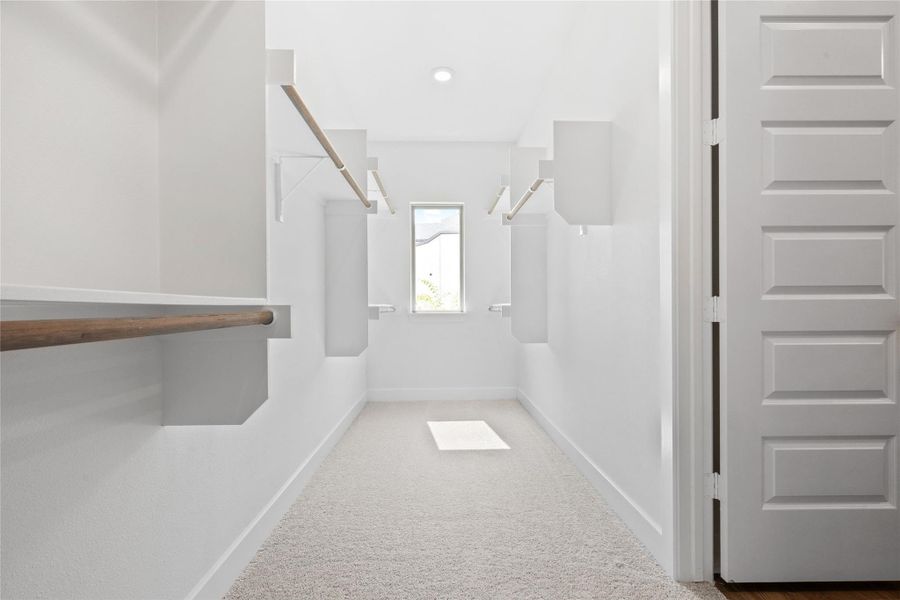 Spacious closet with light colored carpet Spacious closet with light colored carpet