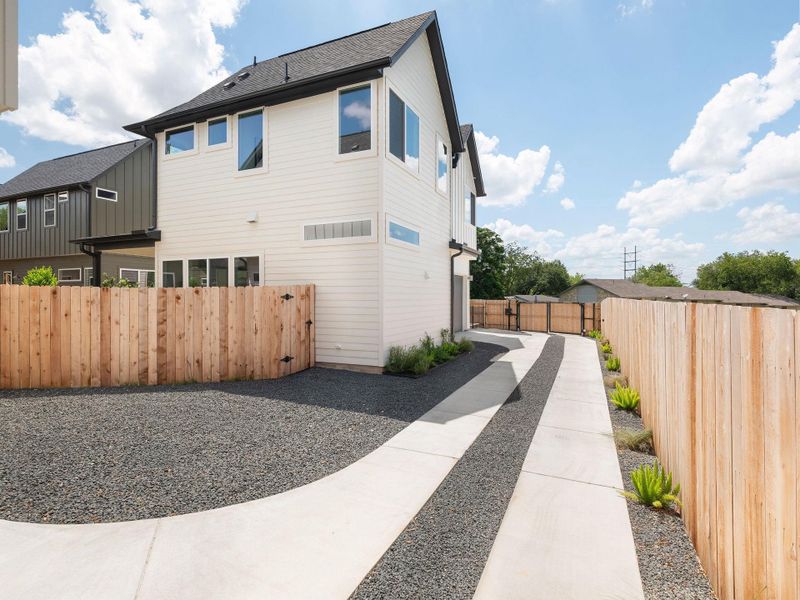 A modern facade with crisp lines, a clean driveway, and a natural wood fence defines this contemporary home.