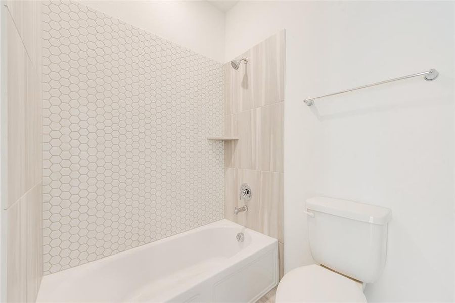 Bathroom featuring bathing tub / shower combination and toilet