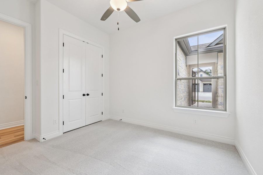 Unfurnished bedroom with light carpet, a ceiling fan, and a closet
