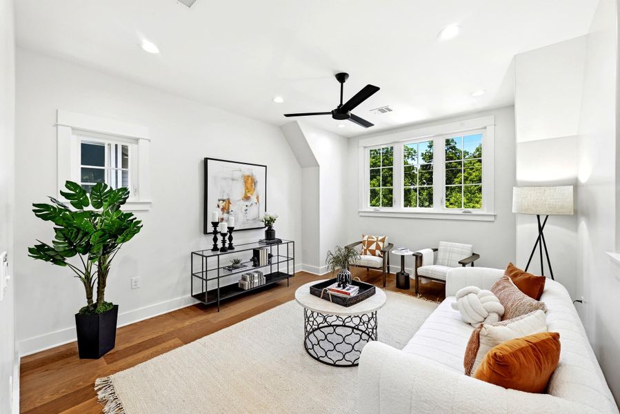 Hardwood flooring and multiple sun-filled windows enhance this inviting living room. Hardwood flooring and multiple sun-filled windows enhance this inviting living room.