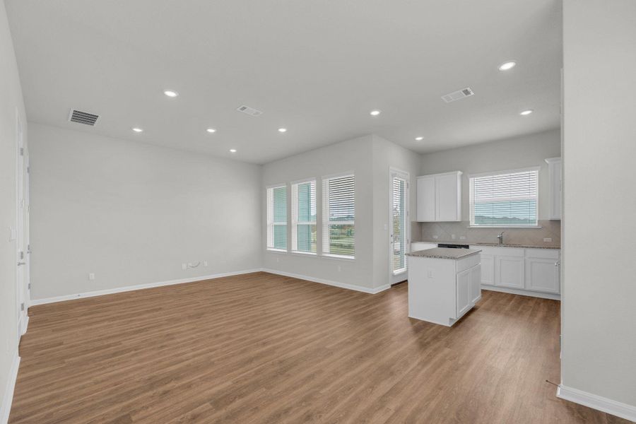 Kitchen featuring white cabinets, a kitchen island, plenty of natural light, recessed lighting, and backsplash