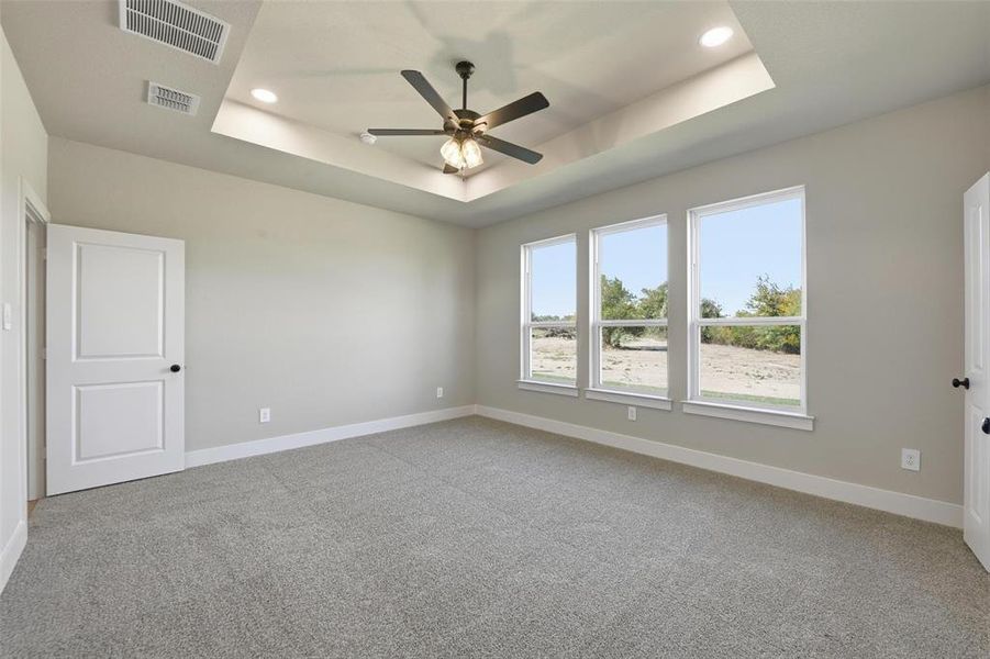 Unfurnished room with a tray ceiling, light carpet, a ceiling fan, and recessed lighting