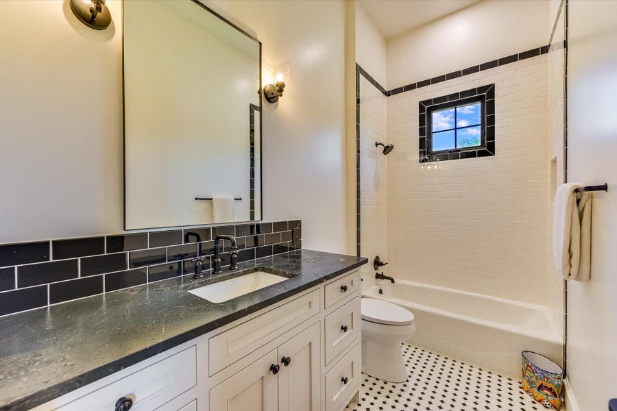 Full bathroom featuring vanity, shower / tub combination, and decorative backsplash