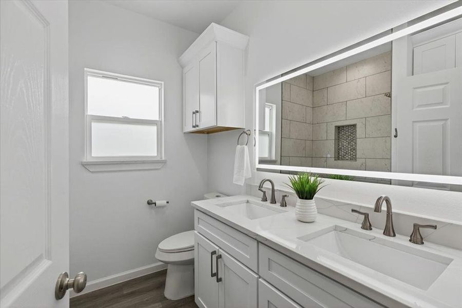 2nd bath featuring a double vanity with undermount sinks, brushed nickel fixtures, and a large backlit mirror.