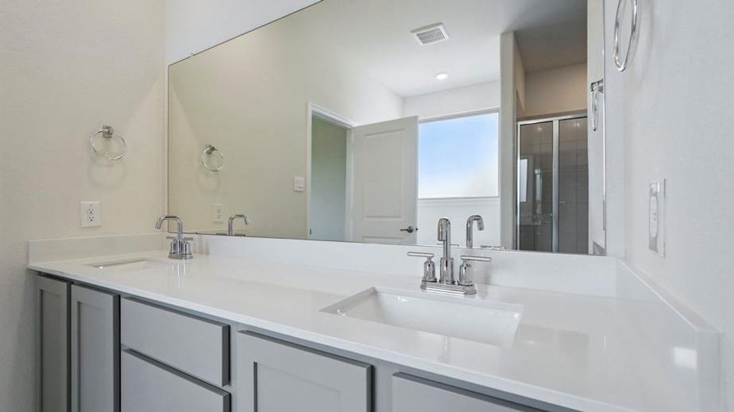 Bathroom featuring double vanity and a shower stall