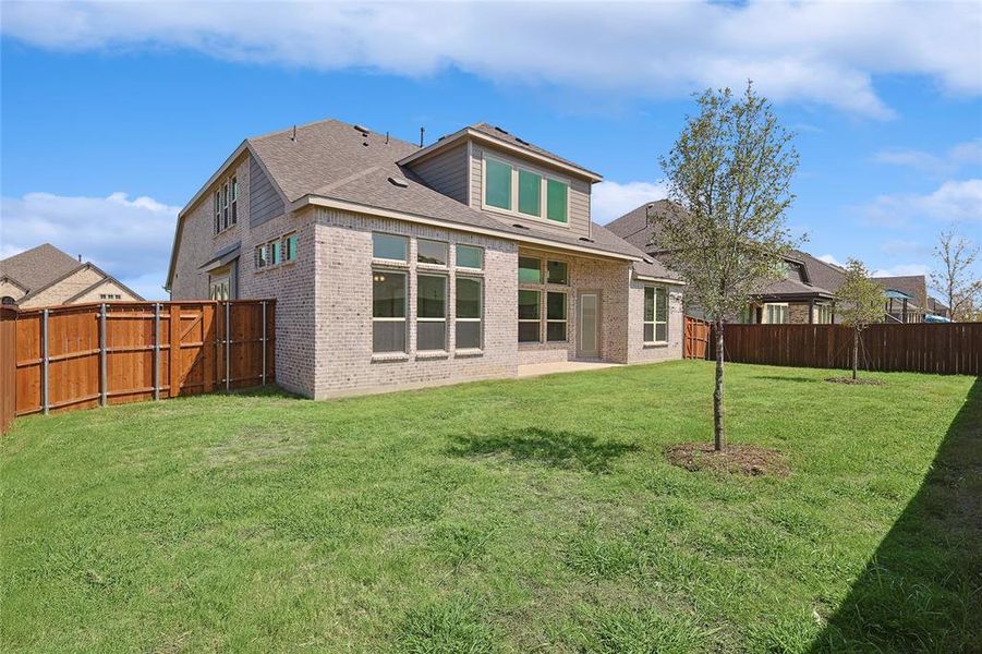 Rear view of house featuring a lawn