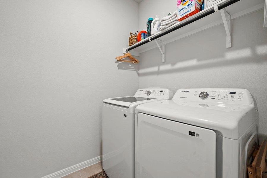 Washroom featuring washing machine and dryer and light tile patterned floors