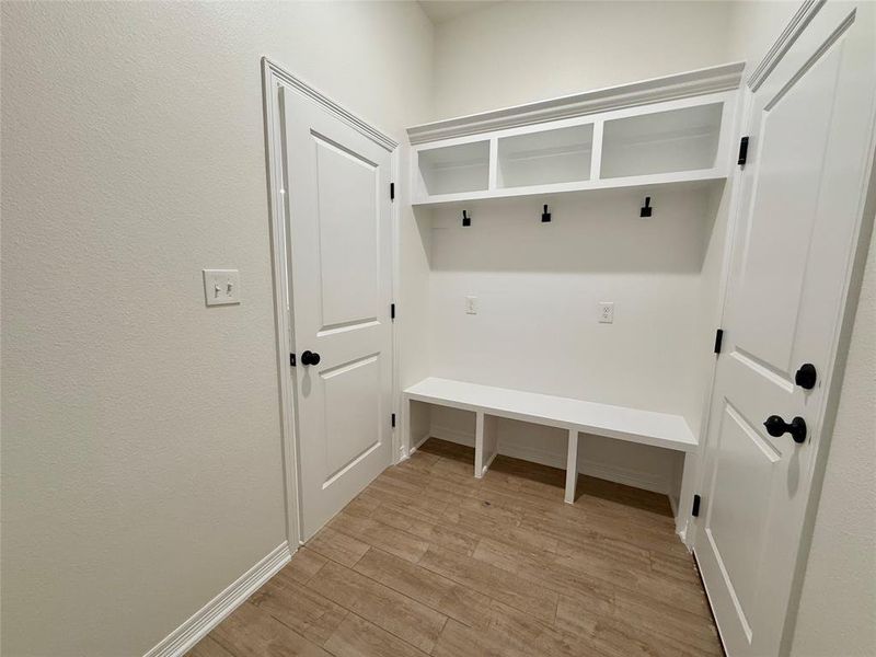 Mudroom with light wood-type flooring and baseboards