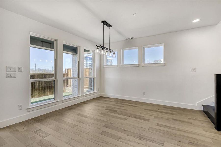 Unfurnished dining area with light wood-style floors and recessed lighting