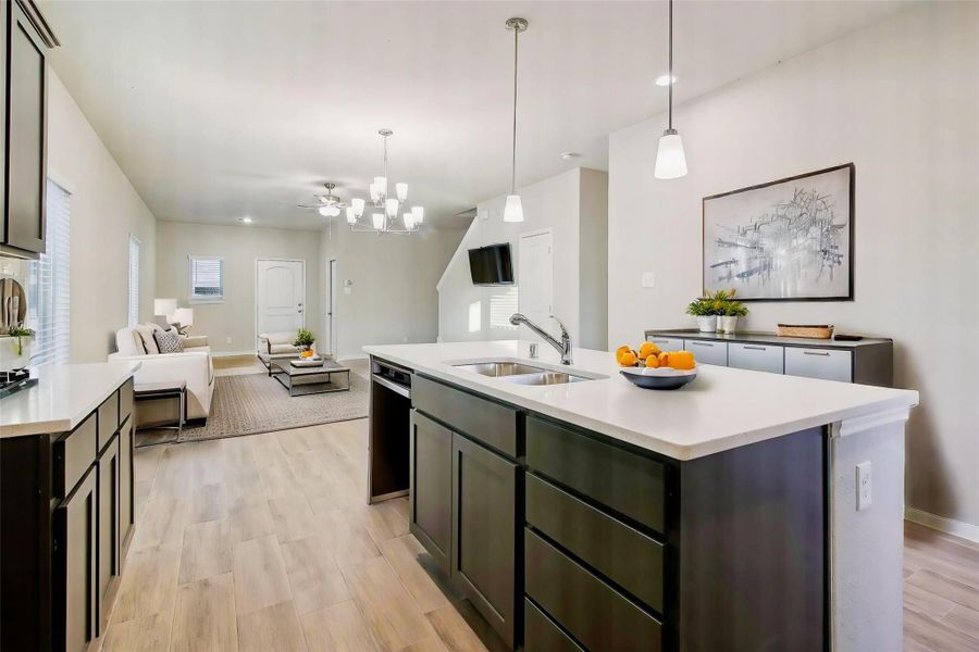 The dark, neat cabinetry offers a beautiful contrast against the white, spacious countertops.