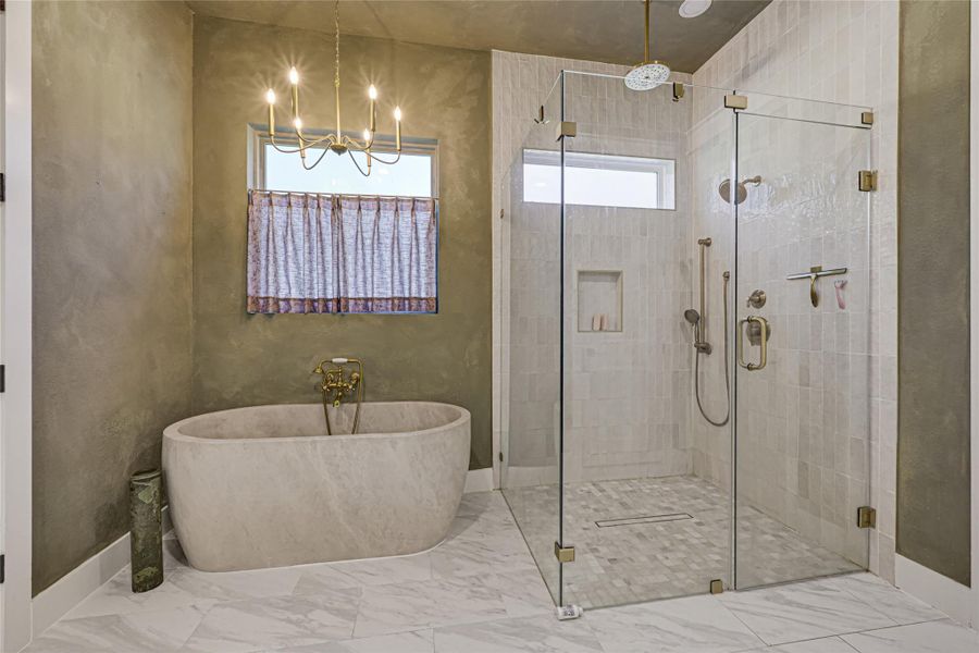Spa inspired primary bath featuring a show stopping custom stone soaking tub.