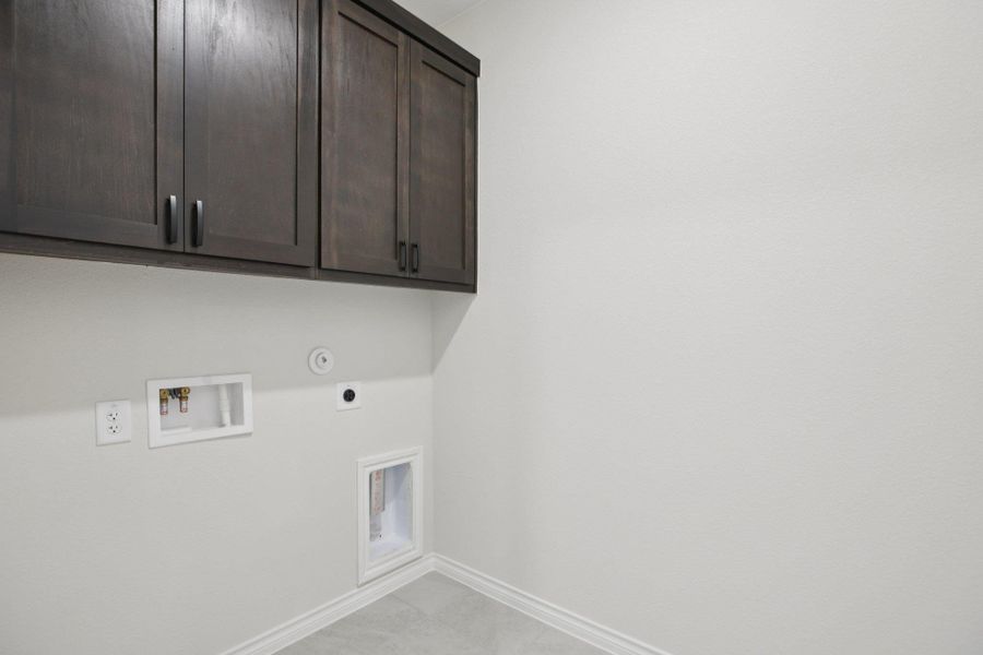 Laundry room featuring cabinet space, washer hookup, light tile patterned floors, and hookup for an electric dryer