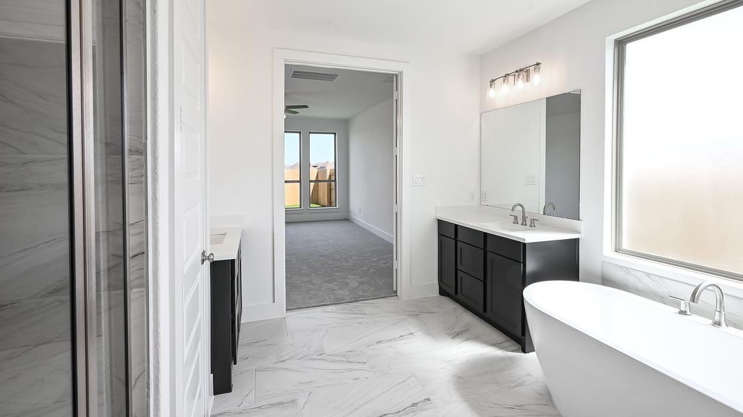 Full bathroom featuring marble look tile flooring, vanity, and a soaking tub Full bathroom featuring marble look tile flooring, vanity, and a soaking tub