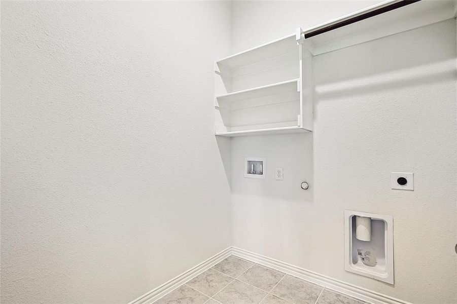 Clothes washing area with washer hookup, light tile patterned floors, hookup for an electric dryer, and hookup for a gas dryer