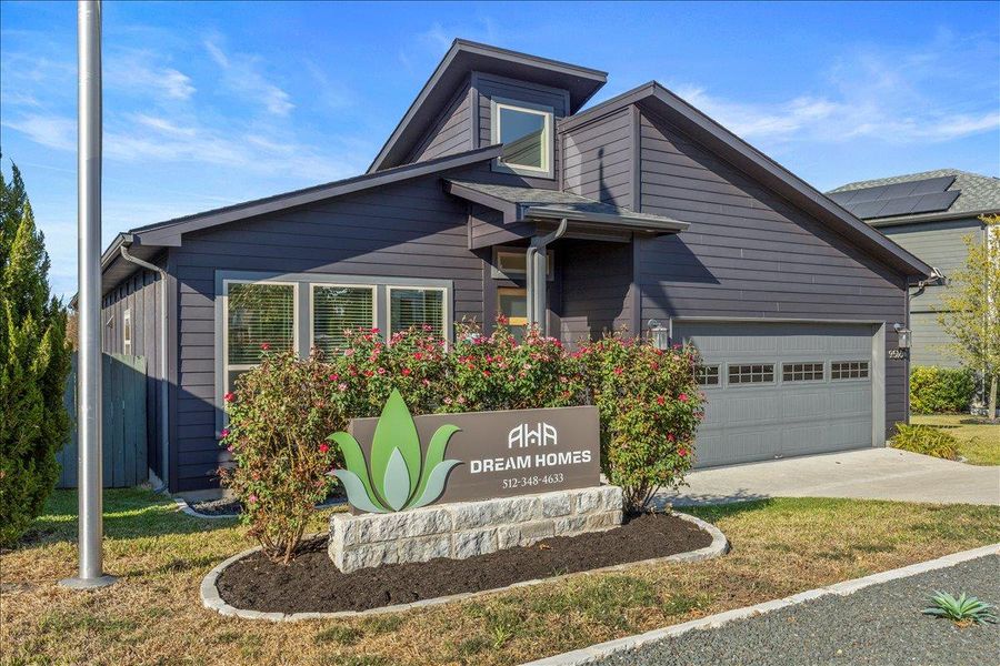 View of front of property with concrete driveway, a front lawn, and a garage